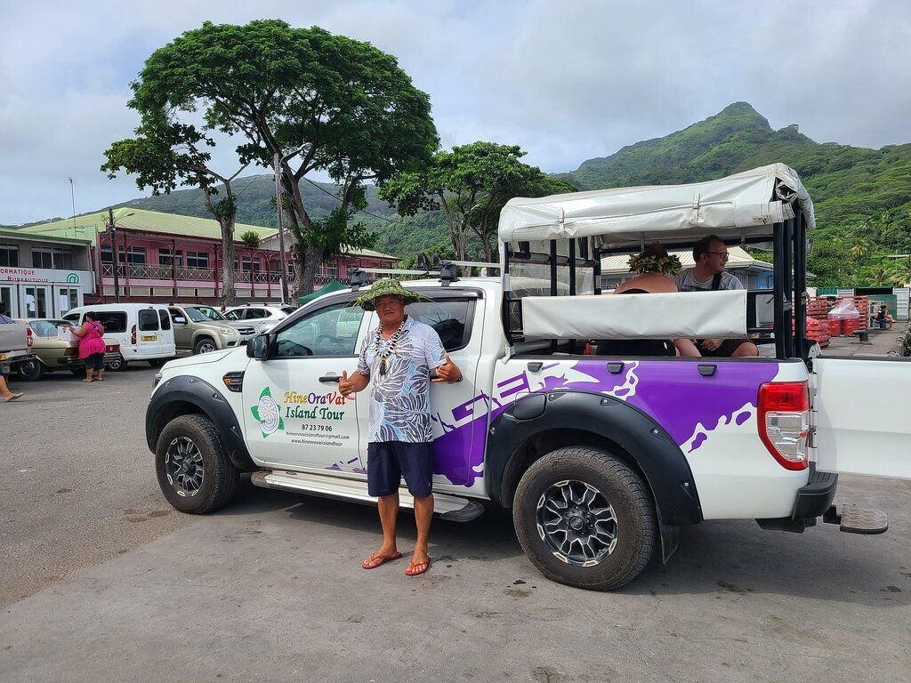 Henri devant le 4x4 avec des clients à l'arrière, sur le quai de Fare à Huahine