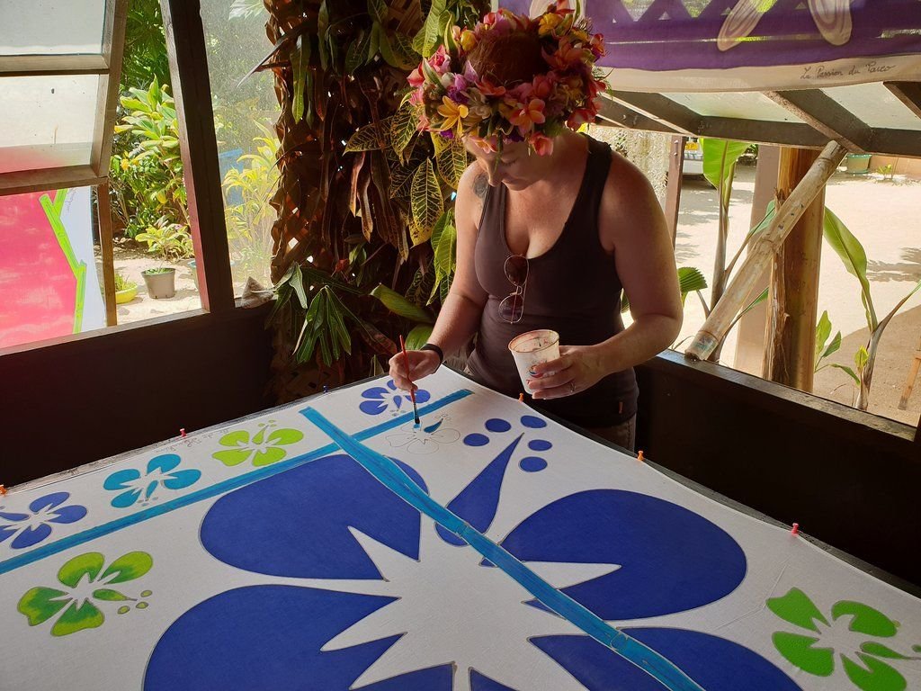 Jeune femme peignant sur du pareo à Huahine